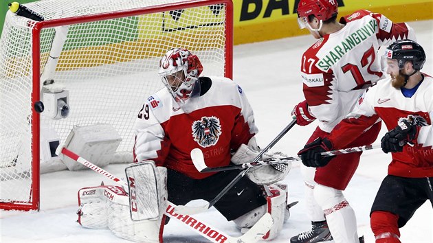 Rakousk� g�lman Bernard Starkbaum zasahuje proti b�lorusk�mu hokejistovi Jegoru �arangovi�ovi (��slo 17).