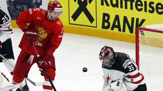 Ruský útočník Michajl Grigorenko (v červeném) se snaží překonat kanadského gólmana Darcyho Kuempera.