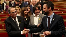 Quim Torra (vlevo) pijímá gratulace poté, co byl katalánským parlamentem...