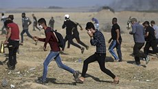 Palestinští demonstranti se utíkají schovat před slzným plynem (15. května...
