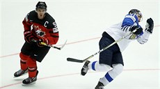Kanadský kapitán Connor McDavid fauluje finského obránce Mira Heiskanena (v...