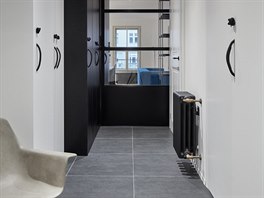 Černá dlažba na podlaze ve vstupní hale opticky rozděluje vstup do bytu od...