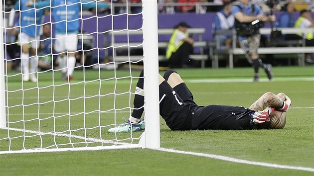 Brankář Loris Karius z Liverpoolu zklamaně leží na trávníku poté, co jej překonal Gareth Bale.