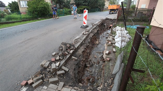 Obyvatelé Zaječova na Berounsku uklízejí následky povodně, která zničila kanalizaci a chodník. (25.5.2018) 