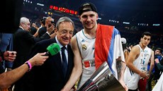 Luka Dončič z Realu Madrid drží trofej pro vítěze Euroligy, naklání se k němu...