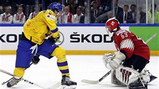 Švédský bek Oliver Ekman-Larsson se snaží vyzrát na švýcarského gólmana...
