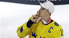 védský kapitán Mikael Backlund líbá zlatou medaili.