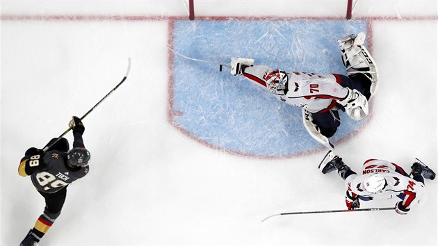 Washingtonsk brank Braden Holtby (uprosted) hokejkou vychytal Alexe Tucha z Vegas. S slem 74 je na kolenou John Carlson.