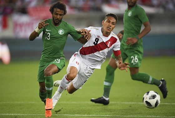 Paolo Guerrero z Peru (v bílém) utíká s míem v zápase se Saudskou Arábií