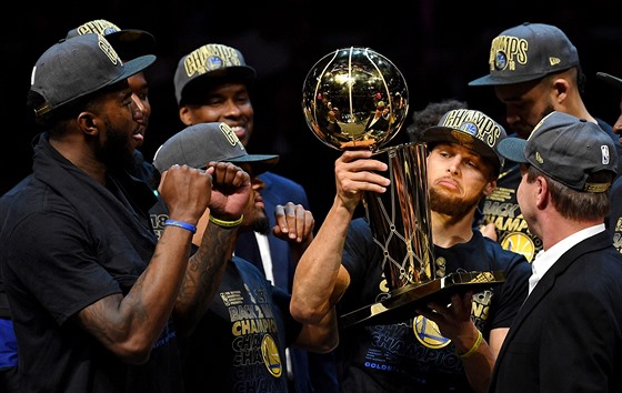 Stephen Curry z Golden State se laská s trofejí pro vítze NBA.