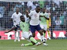 Nigerijský Bryan Idowu (v zeleném) je v souboji s Raheemem Sterlingem z Anglie...