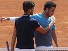 Dominic Thiem (zády) a Marco Cecchinato se objímají po vzájemné konfrontaci v...