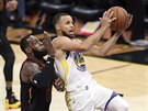 Stephen Curry (uprosted) z Golden State se tlaí mezi LeBrona Jamese (vlevo) a...