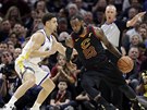 LeBron James (vpravo) z Clevelandu se tlaí kolem Klaye Thompsona z Golden...