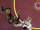 LeBron James (vlevo) z Clevelandu zakonuje na ko Golden State pes JaValeho...