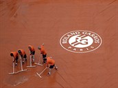 Voda musí pryč. Pracovníci zbavují jeden z pařížských kurtů na Roland Garros...