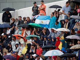 Fanoušci schovaní pod deštníky během čtvrtfinále tenisového grandslamu Roland...