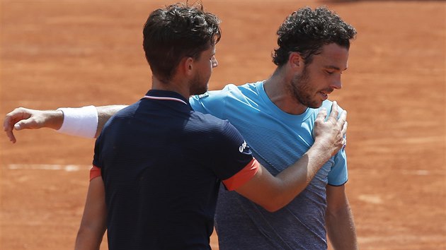 Dominic Thiem (zády) a Marco Cecchinato se objímají po vzájemné konfrontaci v semifinále Roland Garros.