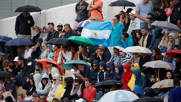 Fanoušci schovaní pod deštníky během čtvrtfinále tenisového grandslamu Roland Garros.