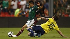 Mexický fotbalista Hirving Lozano kope do míče před skotským Charliem Mulgrewem.