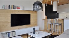 Obývací pokoj s kuchyským koutem. Mramor se opakuje na obkladu u kuchyské...