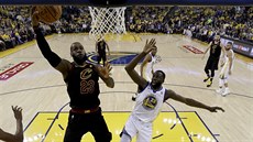 LeBron James (vlevo) z Clevelandu zakonuje kolem Draymonda Greena z Golden...