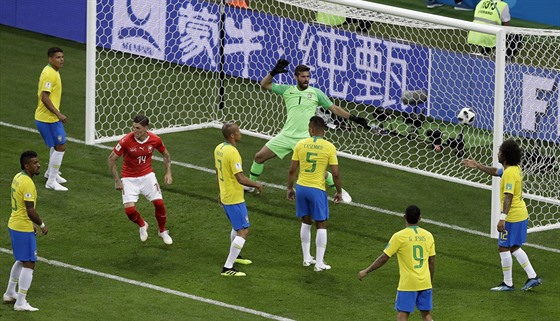 Švýcar Steven Zuber (v červeném) právě překonal přesilu bránících Brazilců a...