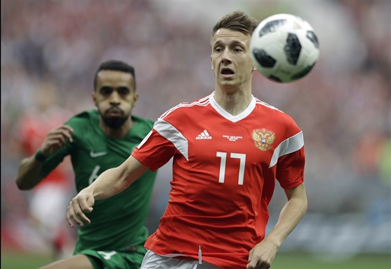 Ruský záloník Aleksandr Golovin zpracovává balon ped saúdskoarabským obráncem...