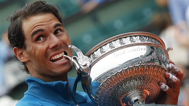 Španělský tenista Rafael nadal kouše do poháru pro vítěze Roland Garros.