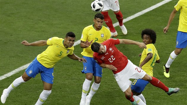Brazilci Thiago Silva (ve lutm uprosted) a Casemiro (vlevo) svdj hlavikov souboj se vcarem Fabianem Schaerem (v ervenm).
