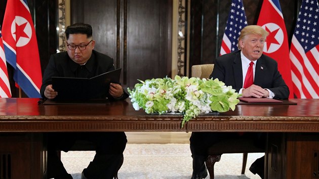 Kim Čong-un si čte společné prohlášení, které právě podepsal, zatímco Donald Trump říká novinářům, že je to velmi důležitý a komplexní dokument. (12. června 2018)