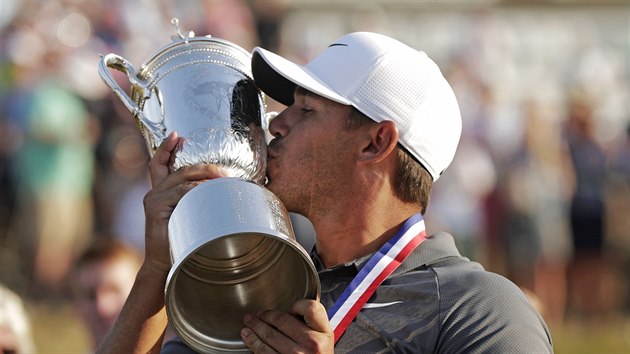 Brooks Koepka líbá trofej pro vítěze US Open.