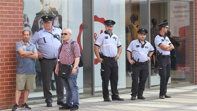 Policisté dohlížející na klidný průběh demonstrace u ústeckého obchodního centra Forum proti vystěhování obyvatel ze dvou zdejších ubytoven.