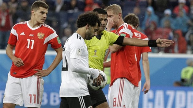 JDU KOPAT. Sudí Caceres nařizuje pokutový kop pro Egypt a balon popadl Mohamed Salah.