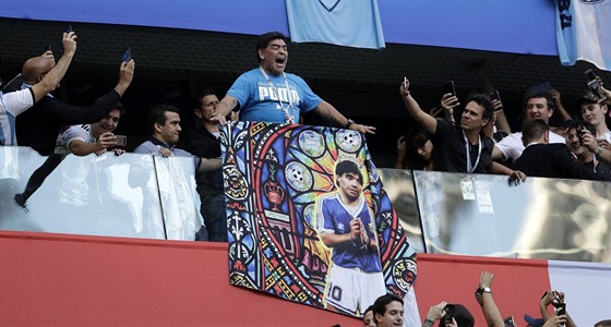 Diego Maradona se speciální vlajkou sleduje duel Argentiny s Nigérií.