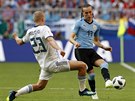 Diego Laxalt (Uruguay) se snaí odehrát mí ped Igorem Smolnikovem (Rusko).