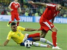 Brazilský záloník Casemiro se snaí skluzem zastavit rozbhnutého Aleksandara...