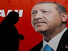 Turkyn prochází pod volebním plakátem tureckého prezidenta Tayyipa Erdogana....