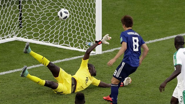 Senegalský brankář Khadim Ndiaye (ve žlutém) se marně natahuje po míči v zápase proti Japonsku.