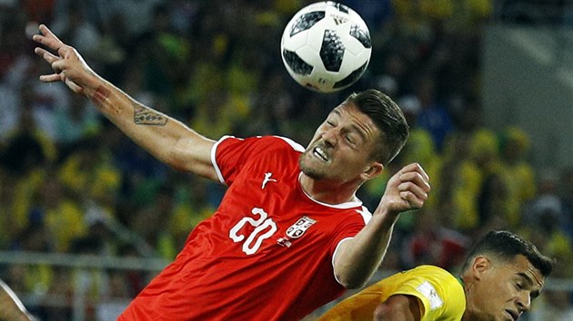 Srbský záložník Sergej Milinkovič-Savič hlavičkuje míč před Coutinhem z Brazílie.