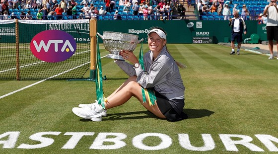 Caroline Wozniacká pózuje s trofejí pro vítězku turnaje v Eastbourne.