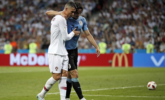 Portugalec Cristiano Ronaldo (vlevo) pomáhá ze hřiště Uruguayci Édinsonu...