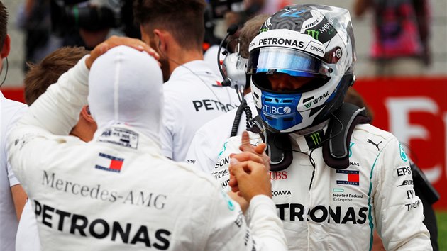 Valtteri Bottas (čelem) a Lewis Hamilton si gratulují k úspěšným jízdám v kvalifikaci na Velkou cenu Rakouska.