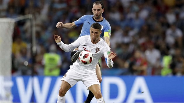 Diego Godn z Uruguaye (v modrm) atakuje Cristiana Ronalda z Portugalska.
