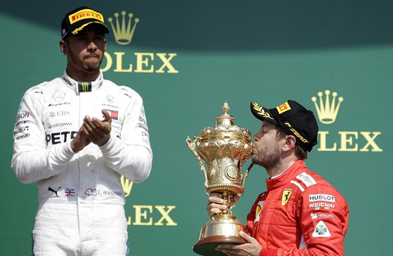 Německý jezdec Sebastian Vettel ze stáje Ferrari líbá trofej pro vítěze Velké...