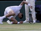 Srbský tenista Novak Djokovi na zemi v duelu 3. kola Wimbledonu.