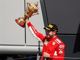 Německý jezdec Sebastian Vettel ze stáje Ferrari zdraví fanoušky po vítězství...