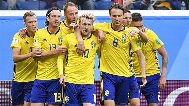 Švédští fotbalisté slaví branku do sítě Švýcarska.