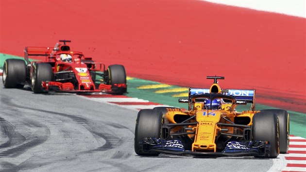 Fernando Alonso na trati Velk ceny Rakouska formule 1, za nm jede Sebastian Vettel.