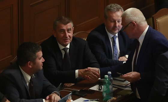 Premiér Andrej Babi (sedící uprosted) s vicepremiérem Janem Hamákem (vlevo) a Richardem Brabcem (vpravo) hovoí ve Snmovn s éfem poslanc ANO Jaroslavem Faltýnkem. (12. ervence 2018)